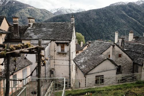Free Charming view of a rural village nestled in the mountains, showcasing traditional slate roof architecture. Stock Photo