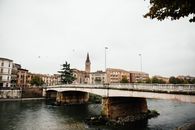 Arched Concrete Bridge Over a River Near Buildings