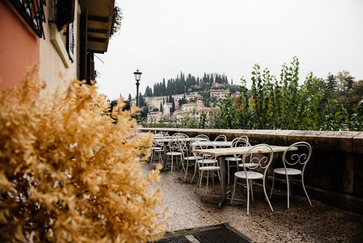 Outdoor Dining Tables And Chairs Near A Concrete Fence