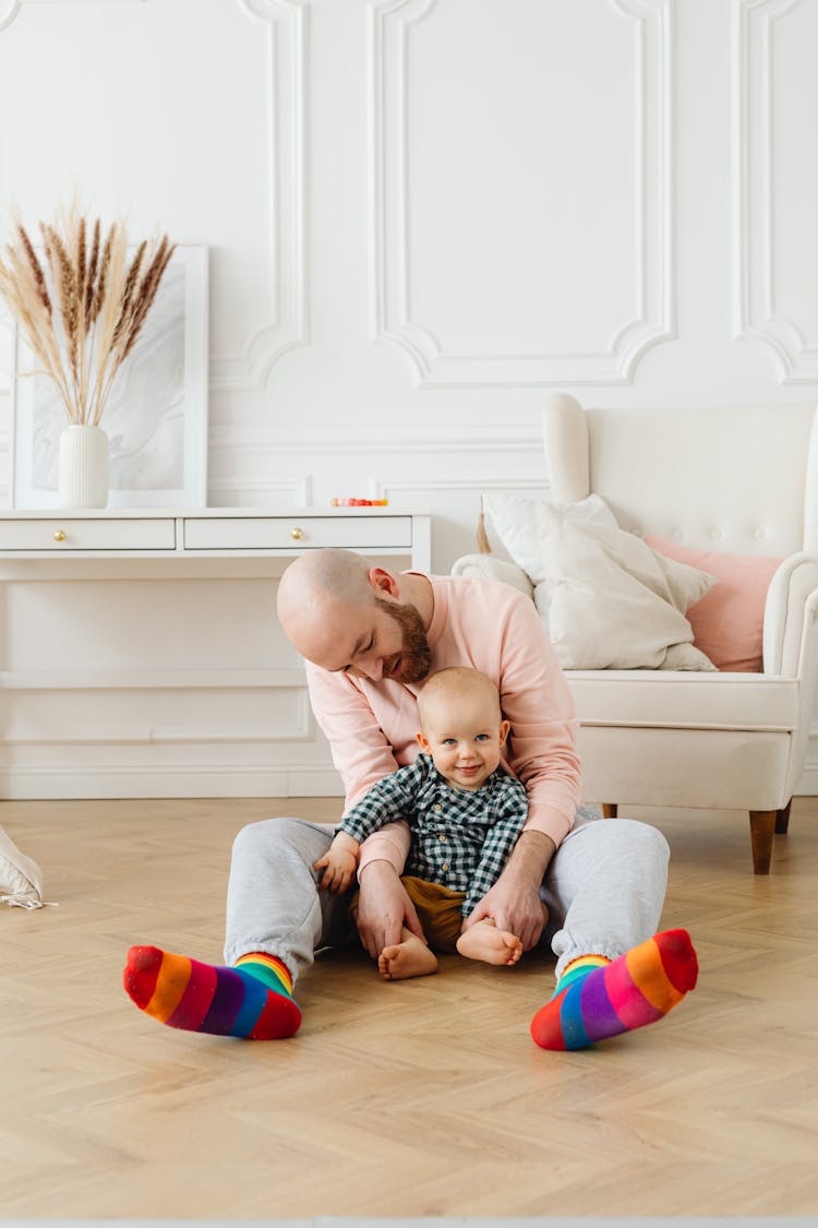 Man Sitting And Cuddling A Baby