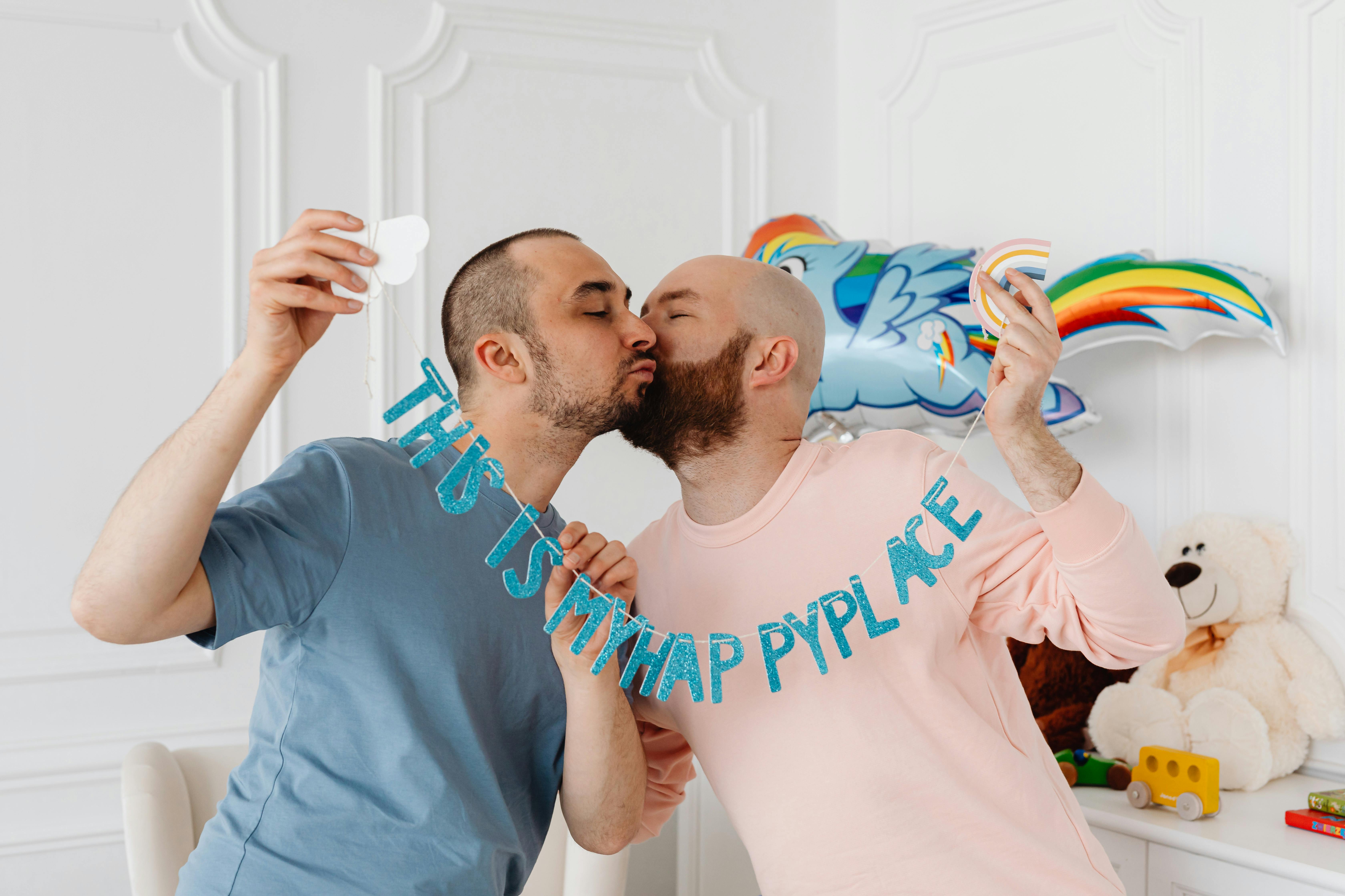 a same sex couple kissing while holding banner