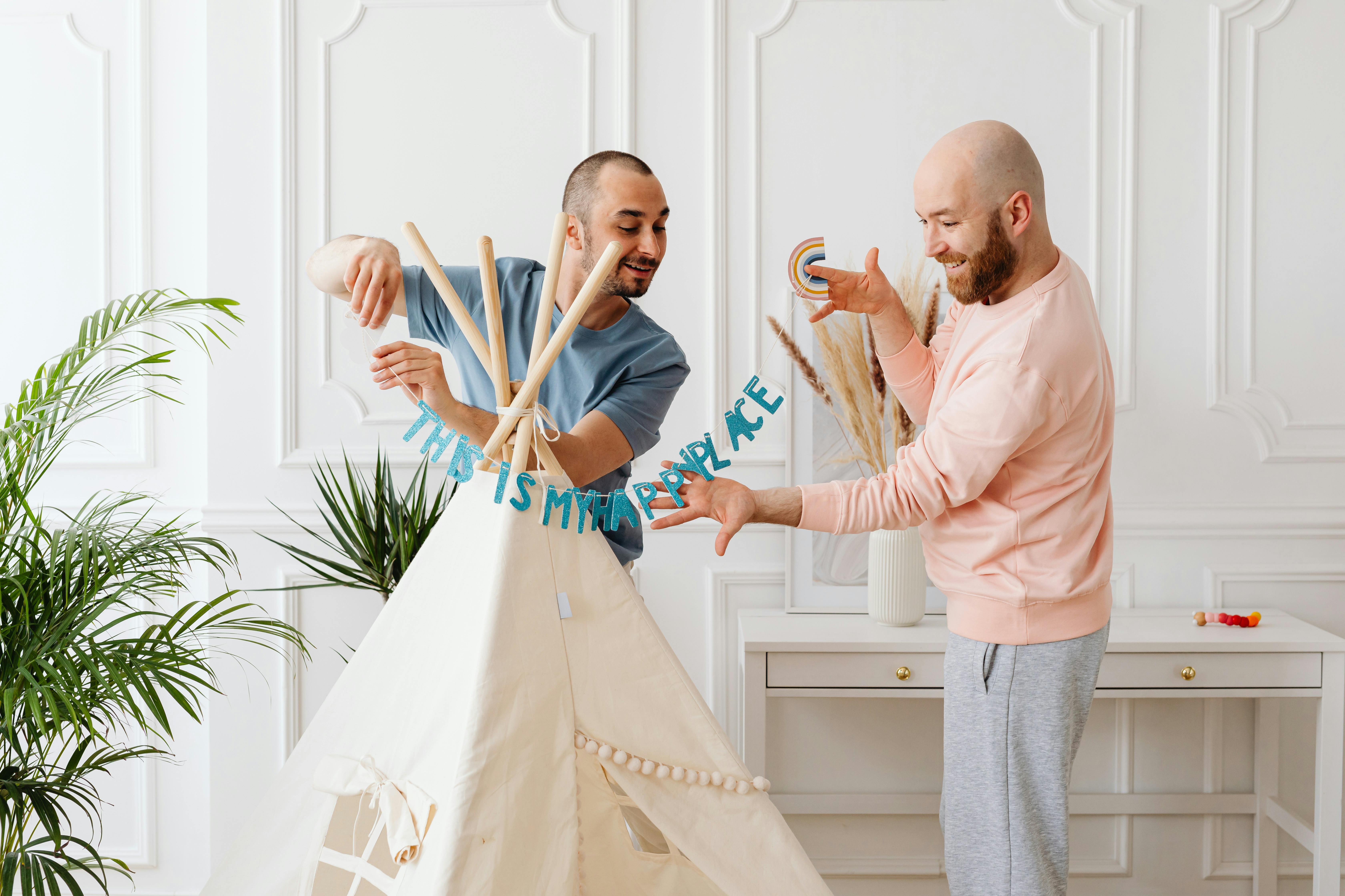 a same sex couple having conversation while fixing a tent