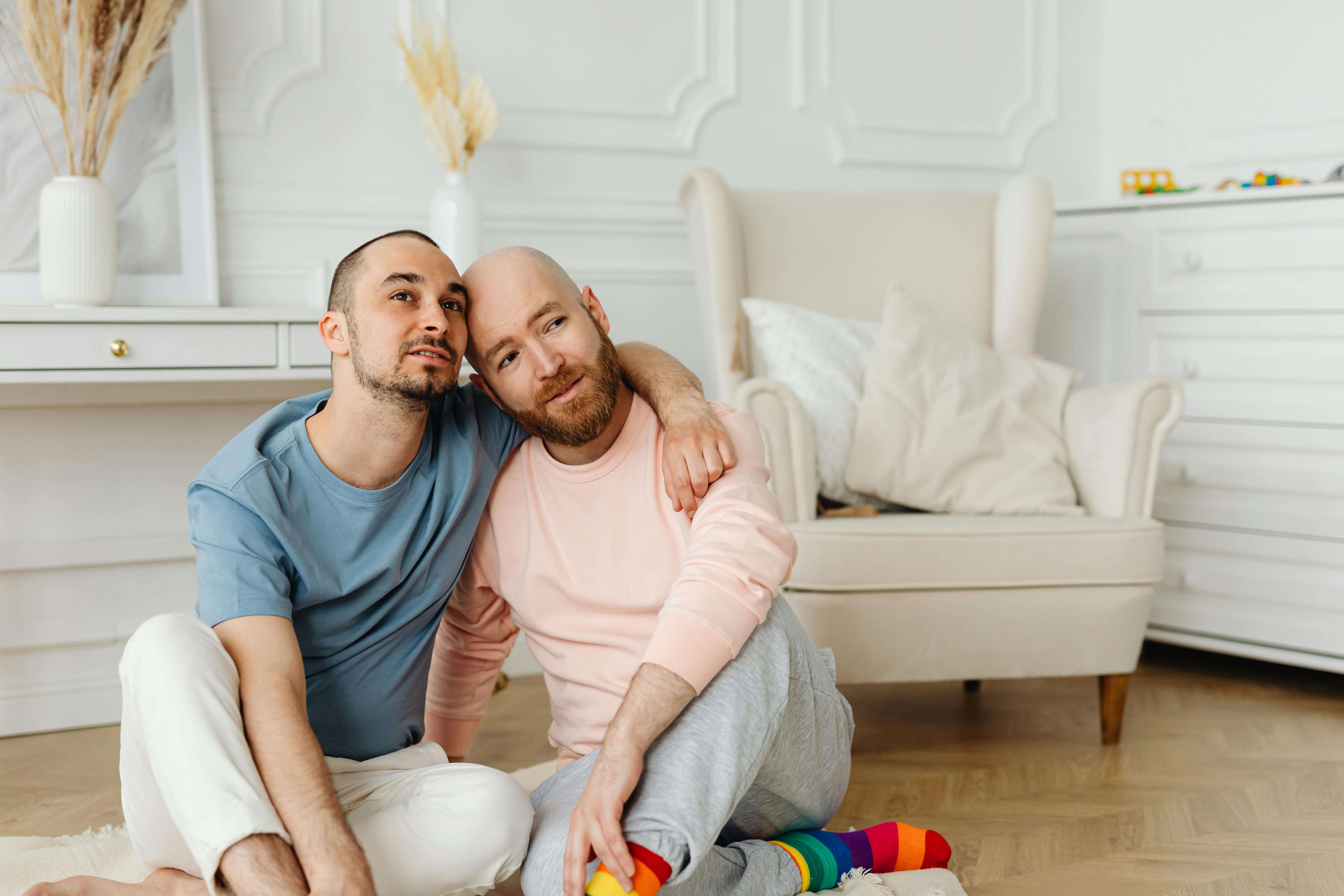 a same sex couple having conversation while sitting on the floor