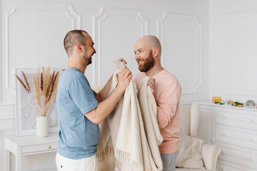 A Happy Couple Folding a Blanket Together