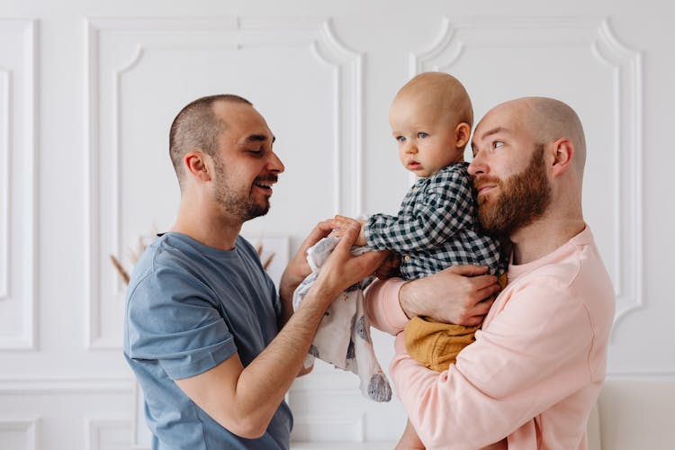 A Same Sex Couple Taking Care Of Their Baby Boy