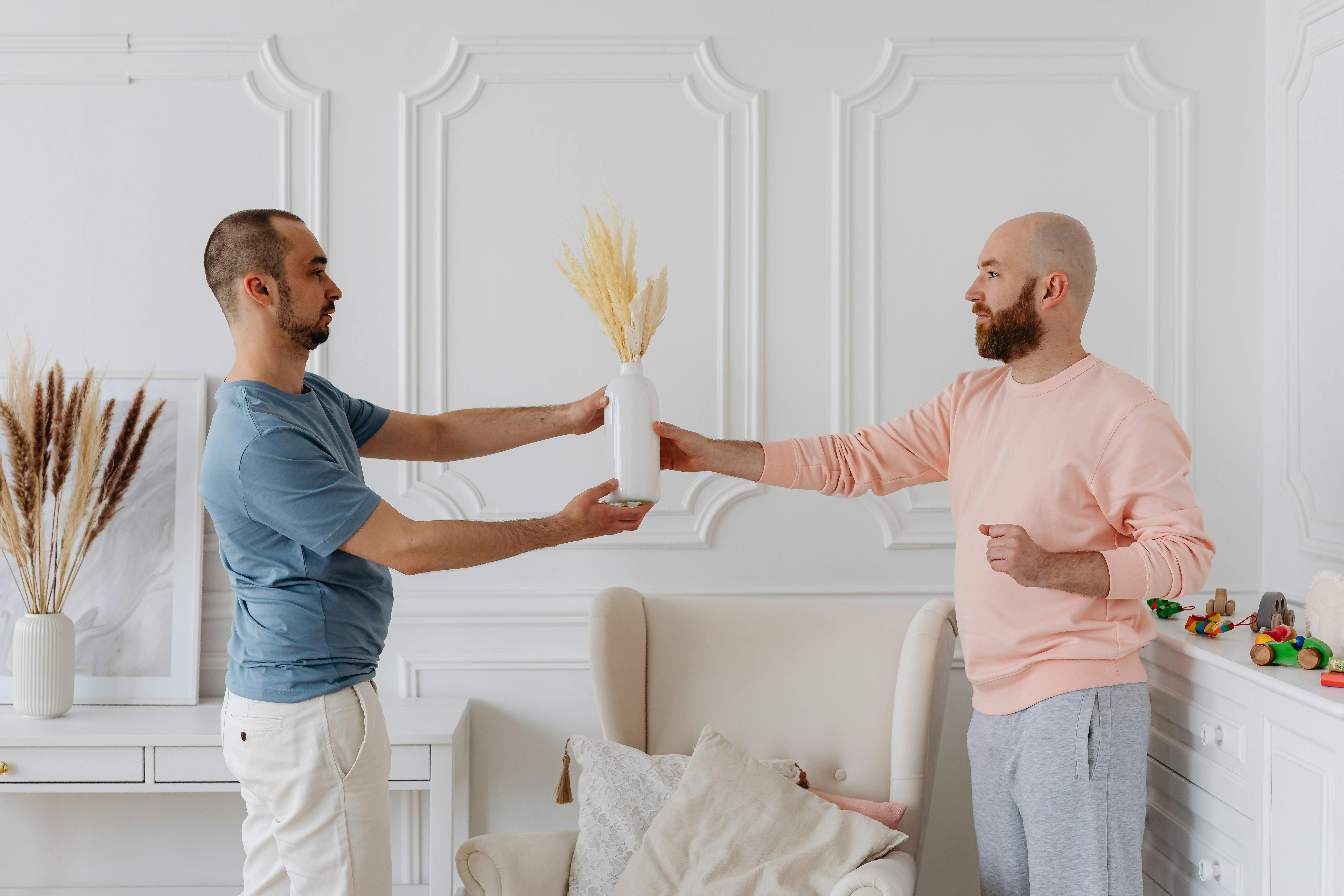 men holding a ceramic vase