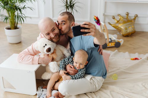 Free A Happy Family Taking Selfie while Sitting on the Floor Stock Photo