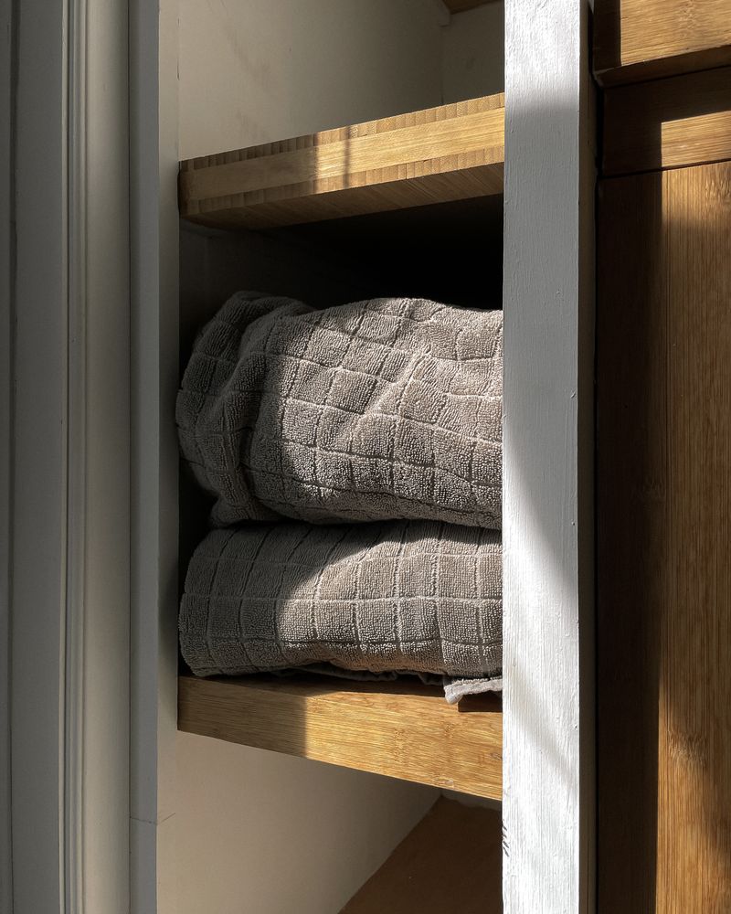 Towels neatly folded on organized bathroom shelves
