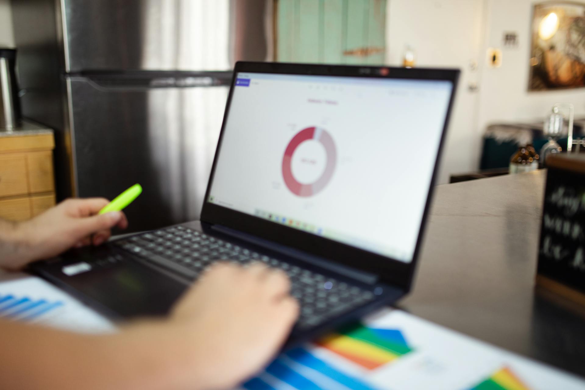 Person analyzing business data on a laptop in a modern indoor setting.