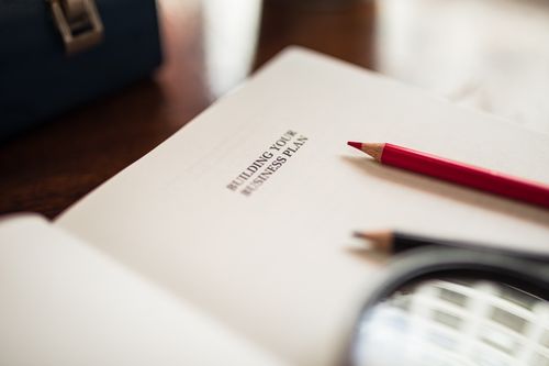 Free Close-up of a business plan and colored pencils on a desk. Stock Photo