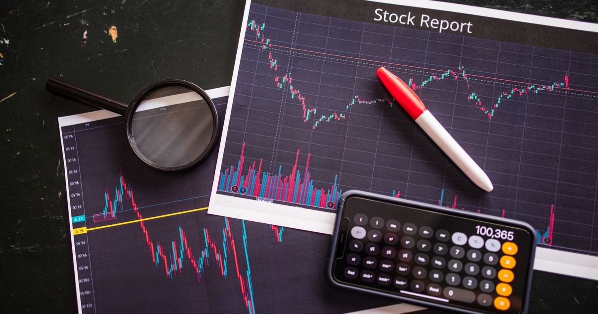 Stock report with charts, calculator, and magnifying glass for financial analysis.