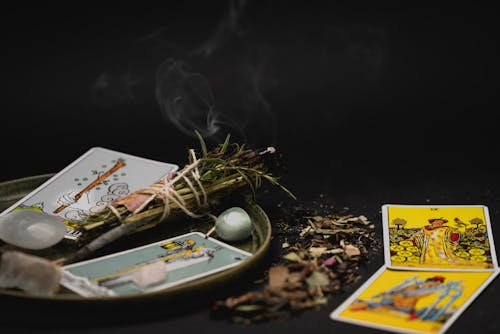 Tarot Cards Near Burning Plants in Close-up Photography
