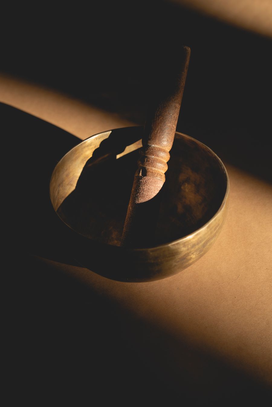 Tuning instruments resting beside a singing bowl in dim calming light