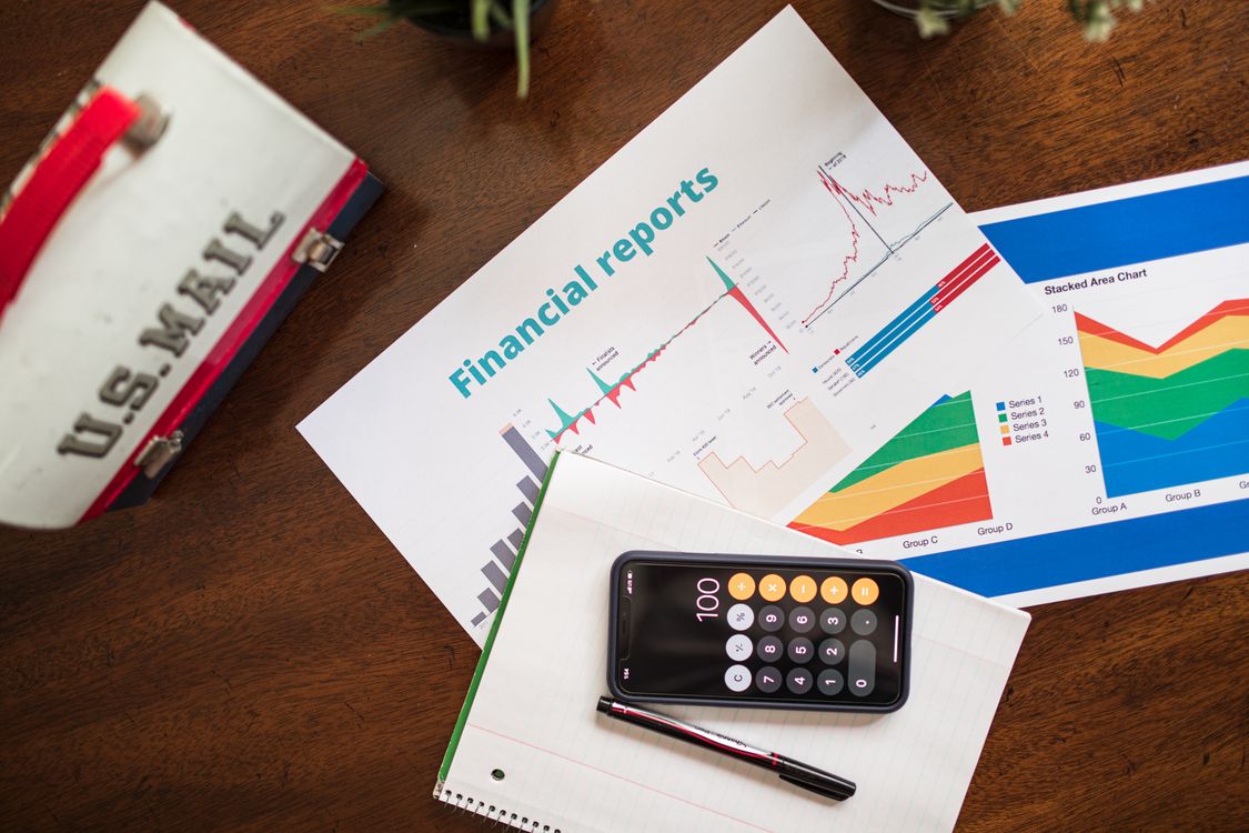 Free Overhead view of financial reports, charts, and a calculator on a desk. Stock Photo