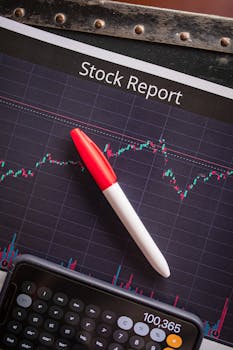 Close-up of a stock report with a pen and calculator for financial analysis.
