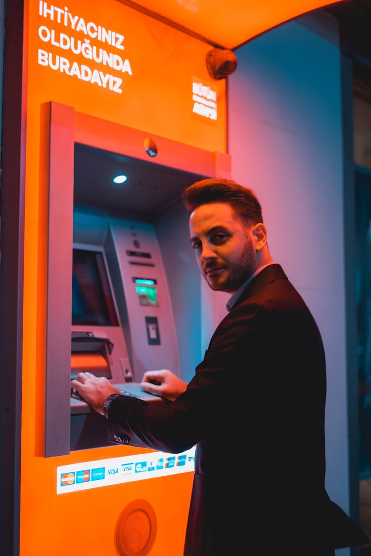 Man In Black Suit Withdrawing From An ATM