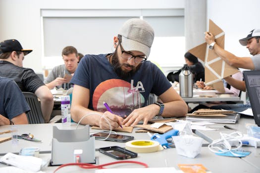 University students working on a cardboard craft project in a classroom.