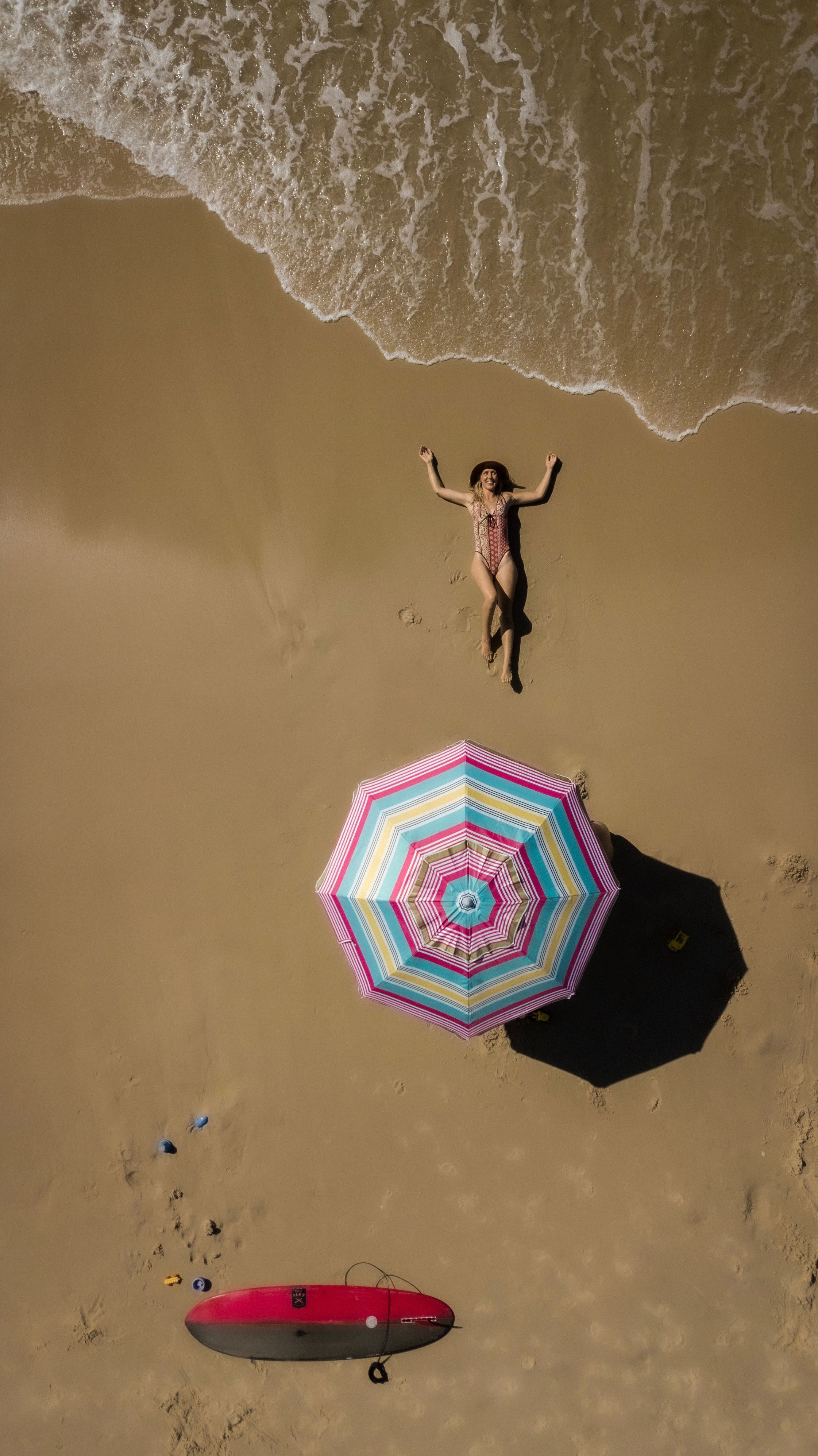 A Woman in a Swimsuit Sitting on the Sand · Free Stock Photo