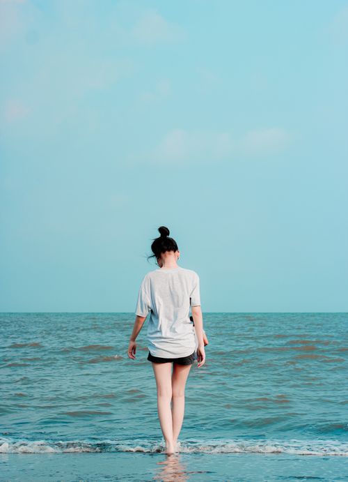 Free A woman enjoys a peaceful moment at the ocean's edge in Tanza, Philippines. Stock Photo