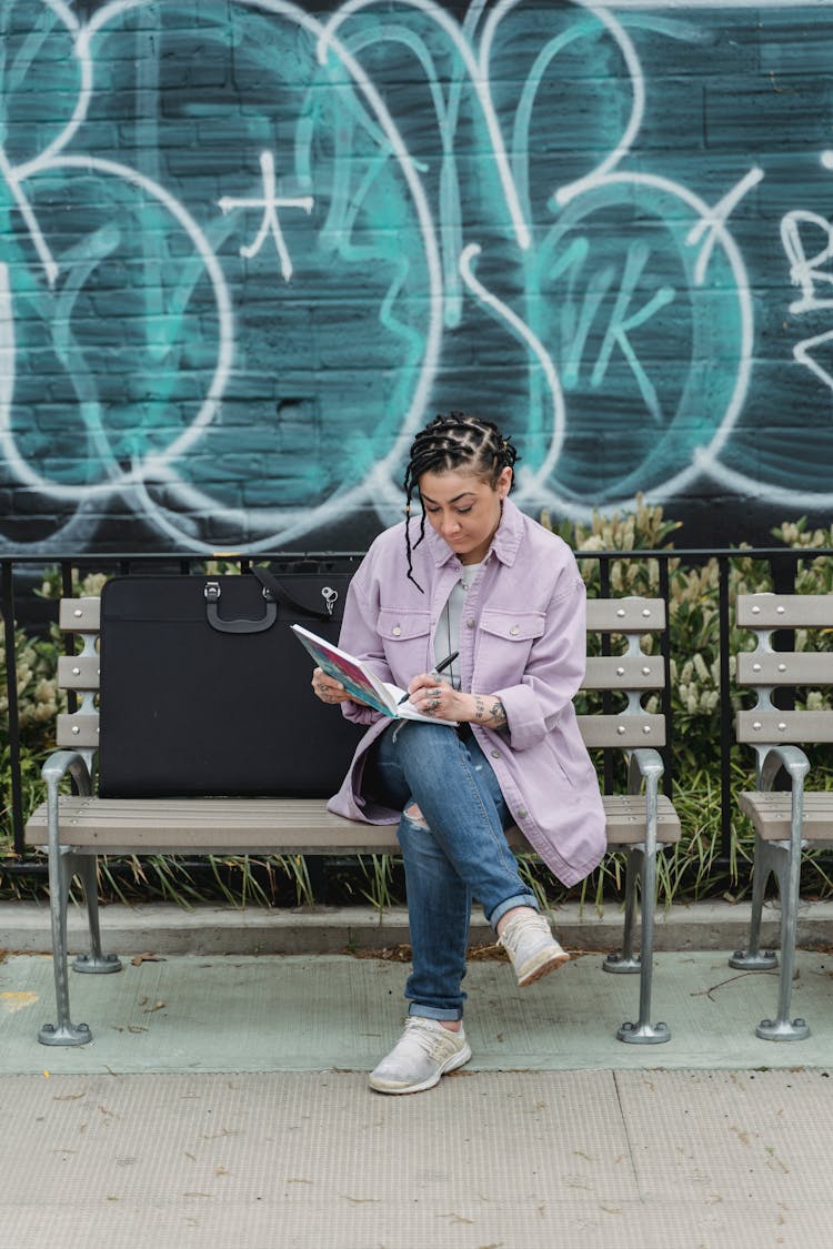 Creative Left Handed Female Designer Doing Sketch On Bench