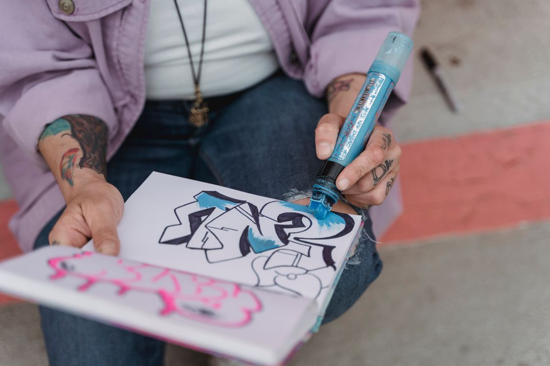 Free Crop artist drawing in sketchbook outside Stock Photo