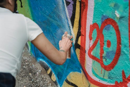 Photo of a Person Spraying Paint on a Wall