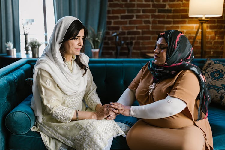 Two Women Sitting On Blue Couch