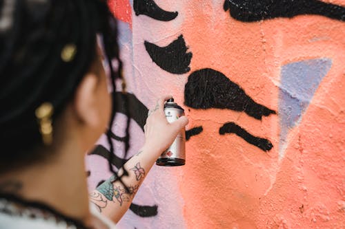 Anonymous person painting wall with spray can
