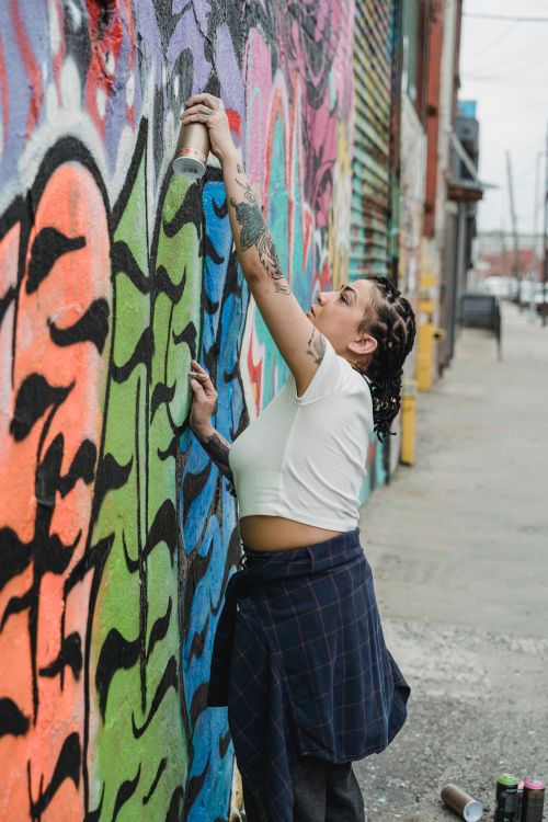 A Woman Spray Painting on the Wall · Free Stock Photo