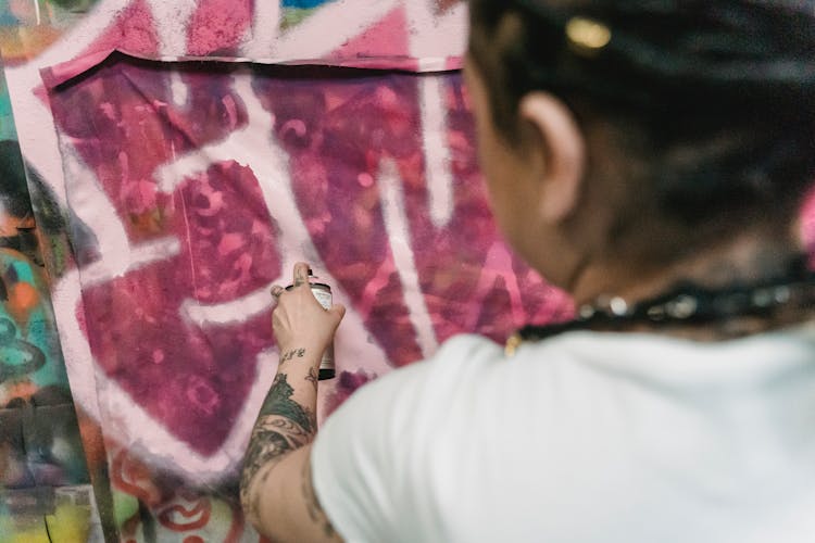 Close-up Of Woman Painting With Spray On Wall