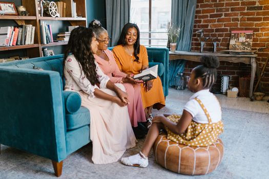 A joyful family group sitting together in a stylish living room with a blue couch.