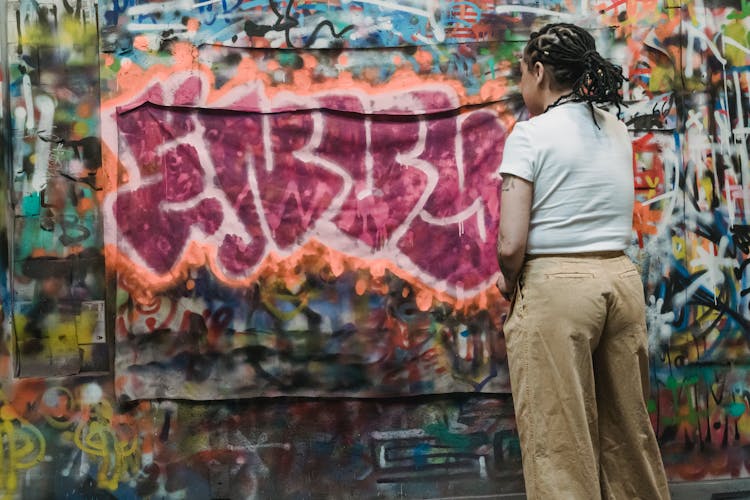 A Woman Spray Painting The Wall