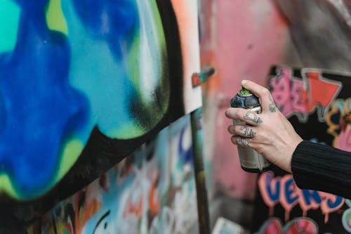 Free A Person's Hand Holding a Spray Can Stock Photo