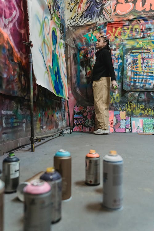 Woman in Brown Pants Using a Spray Can