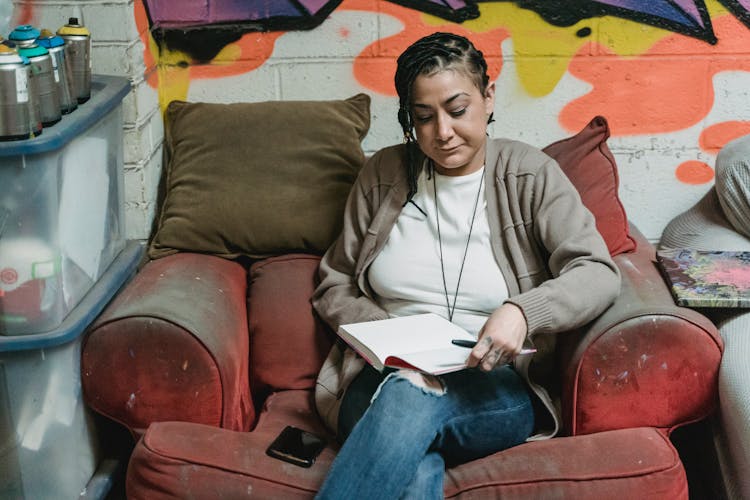 Woman Sitting In An Old Armchair And Drawing 