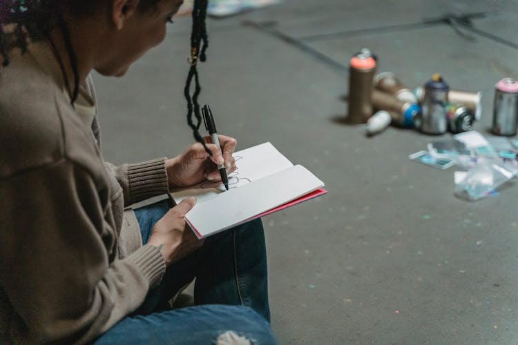 Woman Doodles In A Notebook