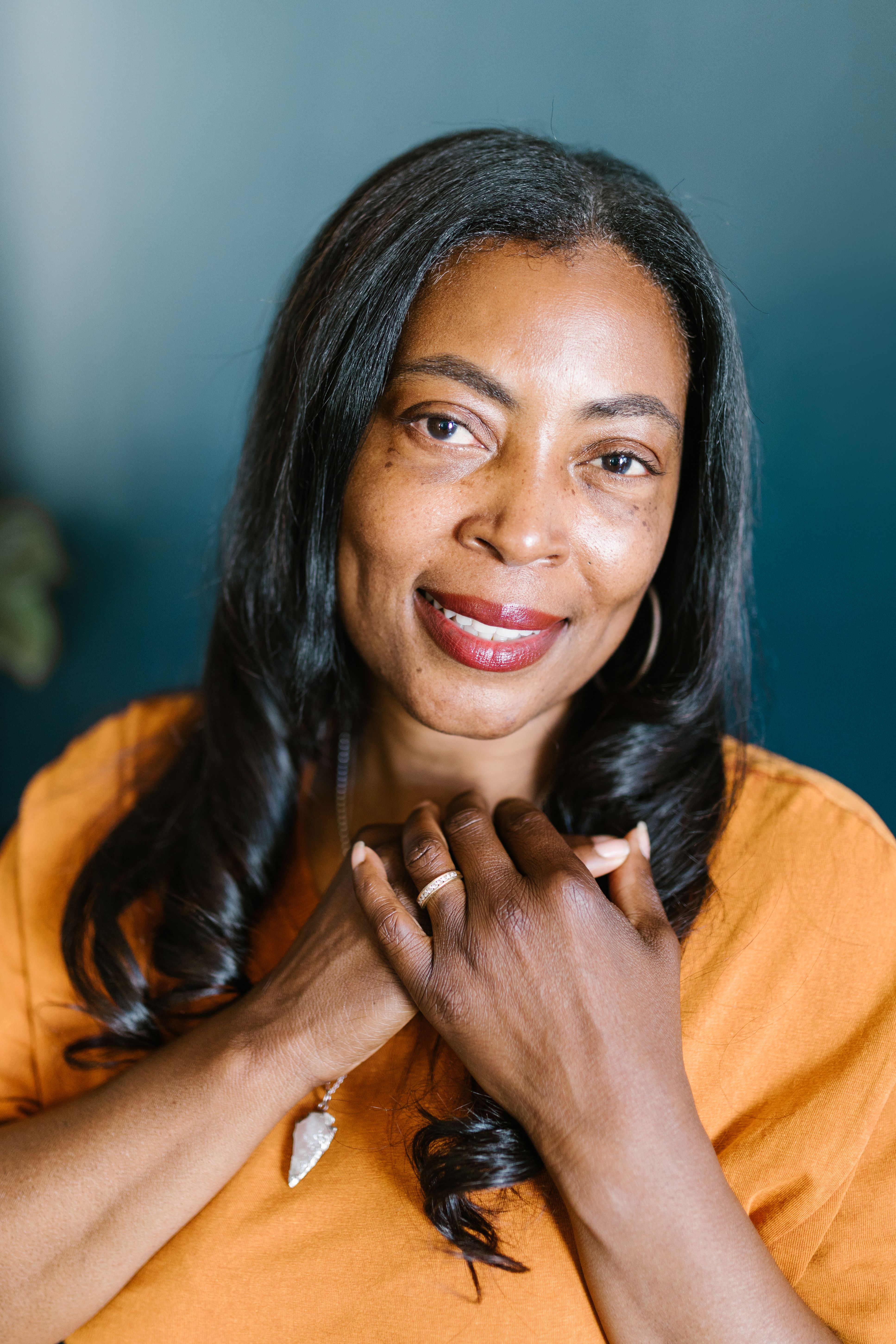 A warm and engaging portrait of a smiling African American woman indoors.