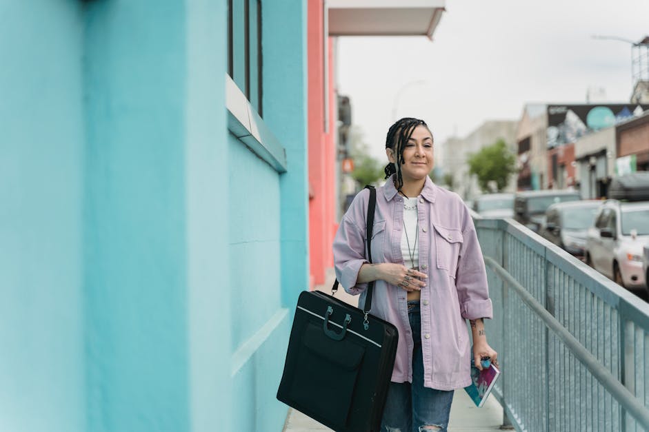 A Woman Carrying a Bag and Talking on the Phone · Free Stock Photo