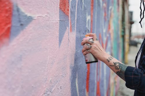 A Person Doing Graffiti on a Wall Using a Spray Paint