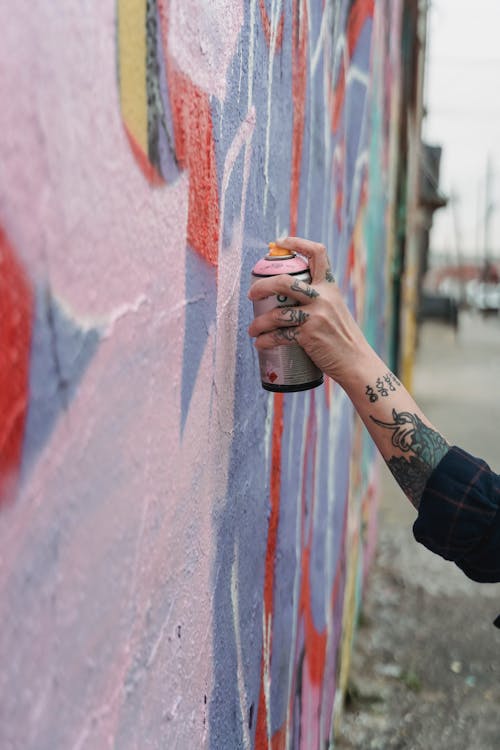 A Person Doing Graffiti on a Wall Using a Spray Paint
