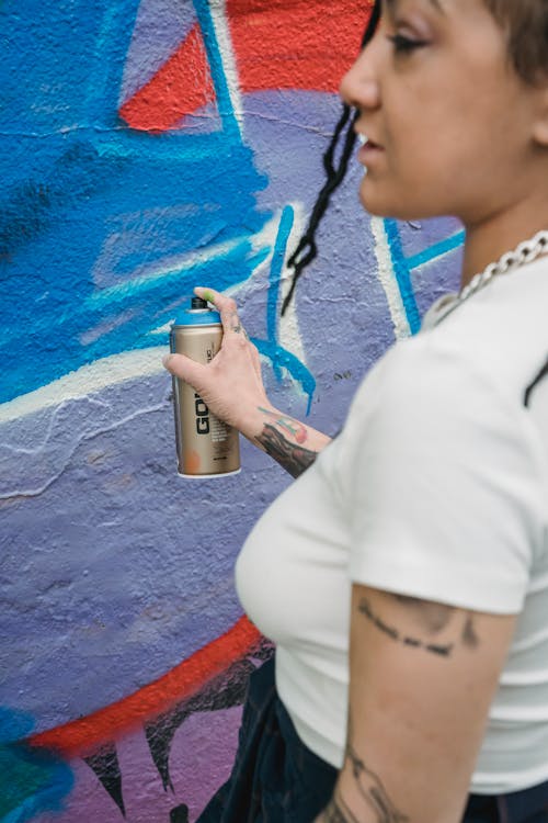 Person in White Shirt Holding a Spray Bottle 