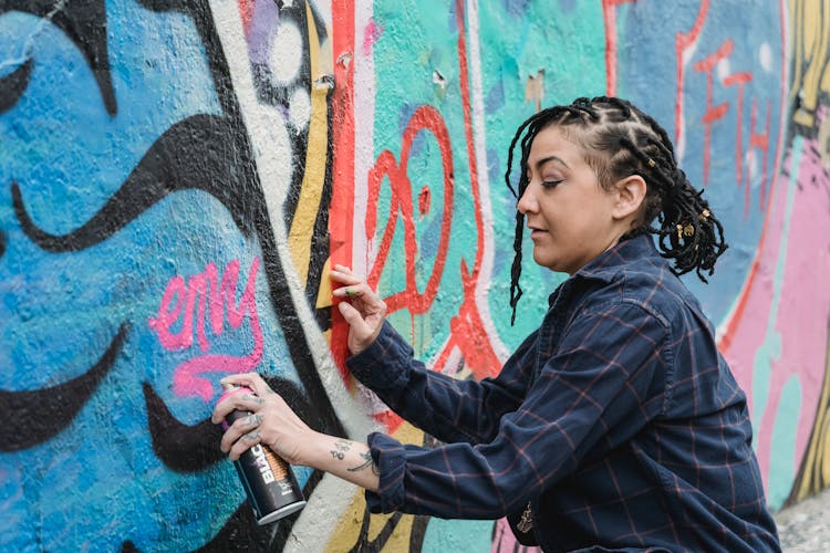 Woman With Tattoos Making Graffiti On Wall