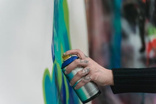 Tattooed Person Holding Spray Paint 