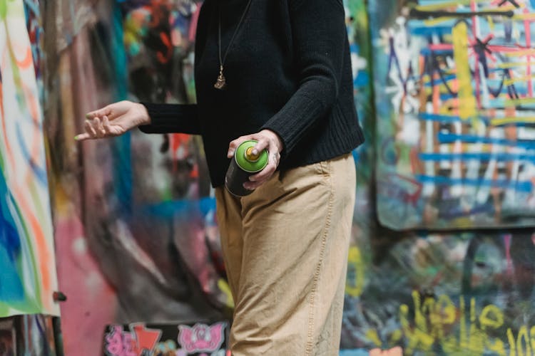 A Person Holding A Can Of Spray Paint