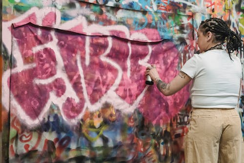 Person in White T-shirt Painting Graffiti