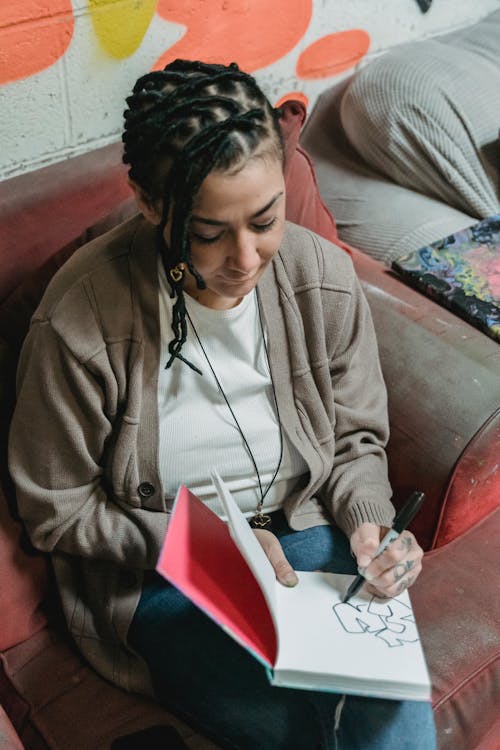 Woman Designing Graffiti in a Notebook 