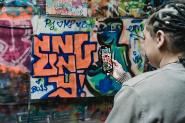 Person Taking Photo Of A Graffiti Wall 