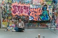 Man in Blue Jacket Sitting on Floor