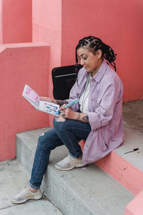 A Woman Doing Painting on the Notebook