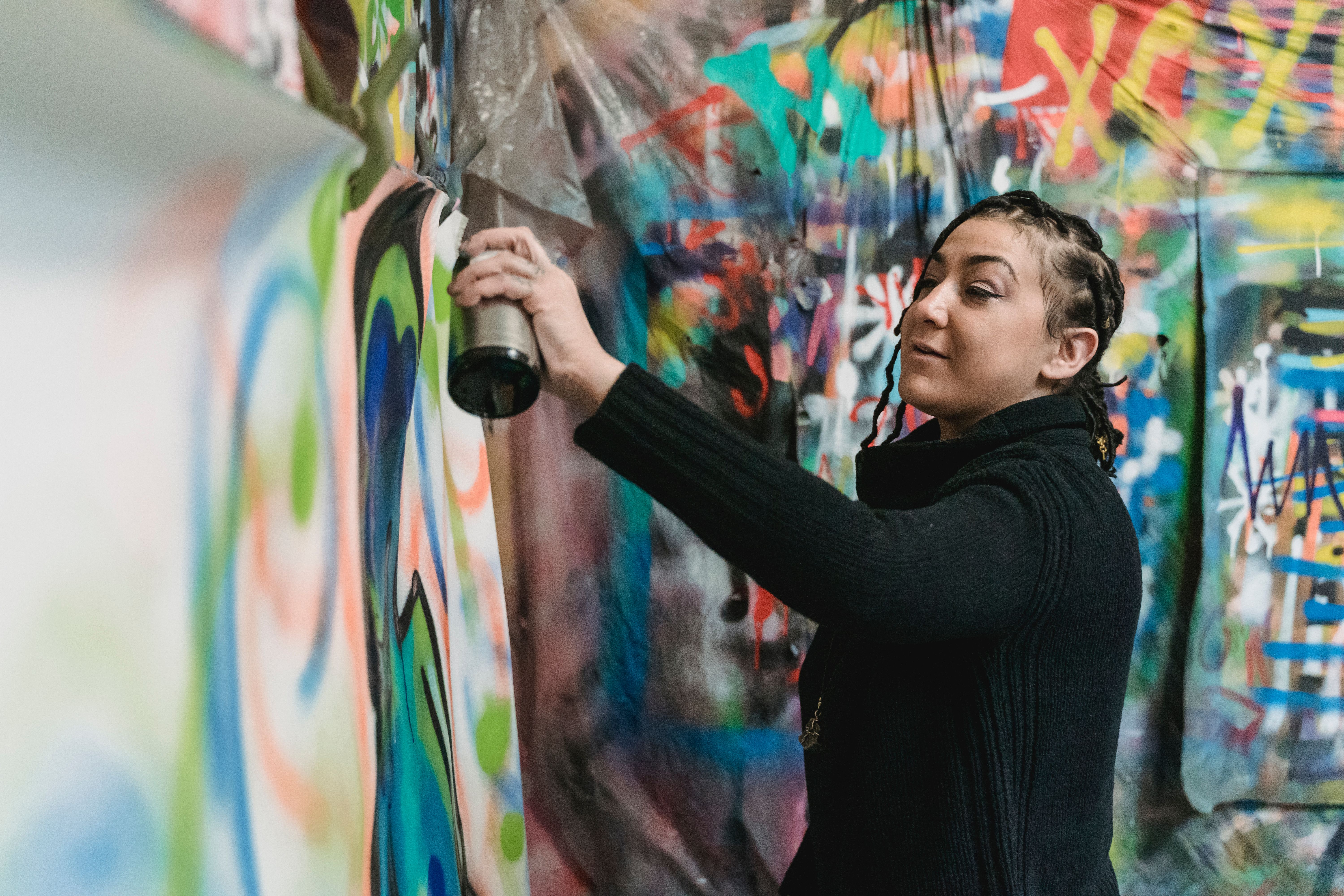 Artista de grafite criando mural colorido com spray